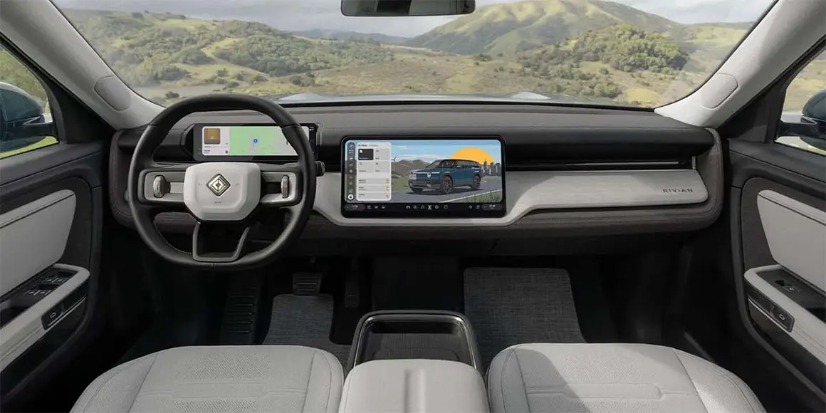 El interior del Rivian R2 muestra un dise&ntilde;o futurista con pantalla t&aacute;ctil y controles digitales.