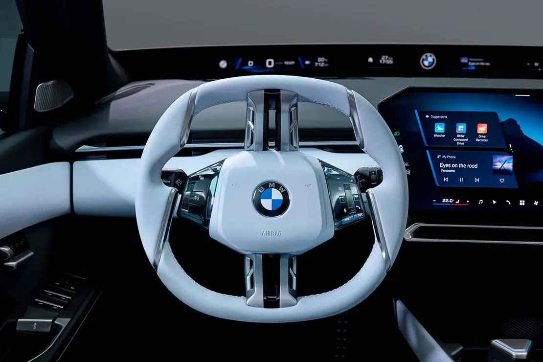 Vista del interior del BMW i3 2026, destacando su volante y panel de control digital.
