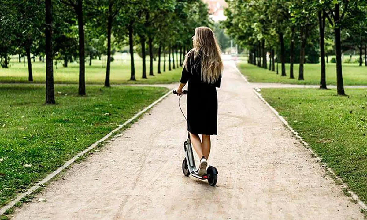 Foto de una chica subida en un patinete el&eacute;ctrico
