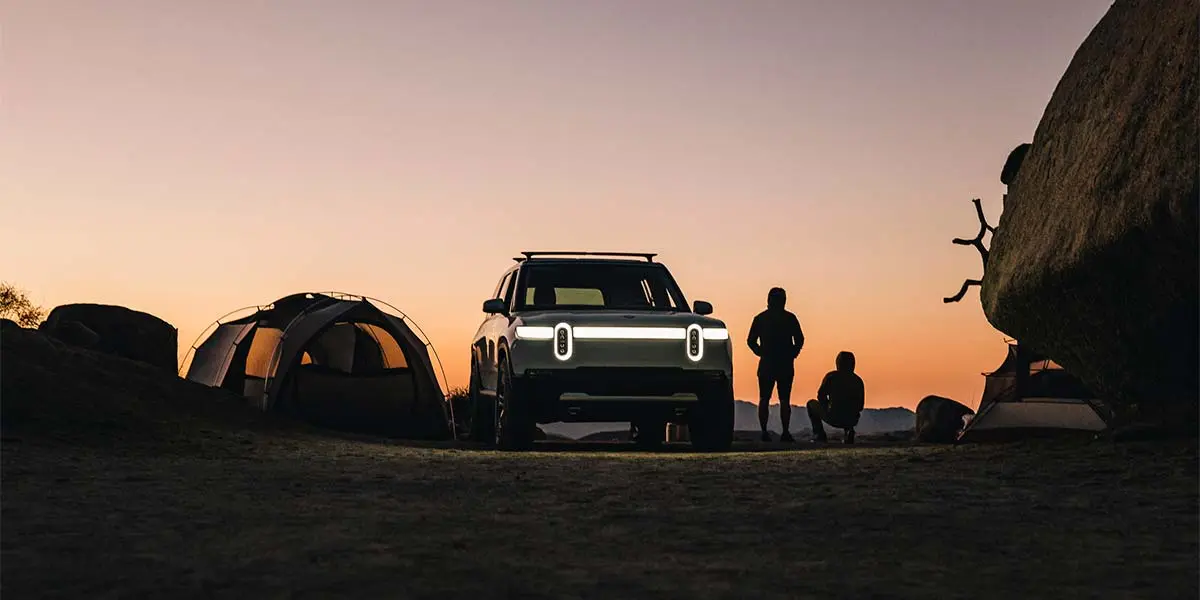 Foto de un coche Rivian al atardecer