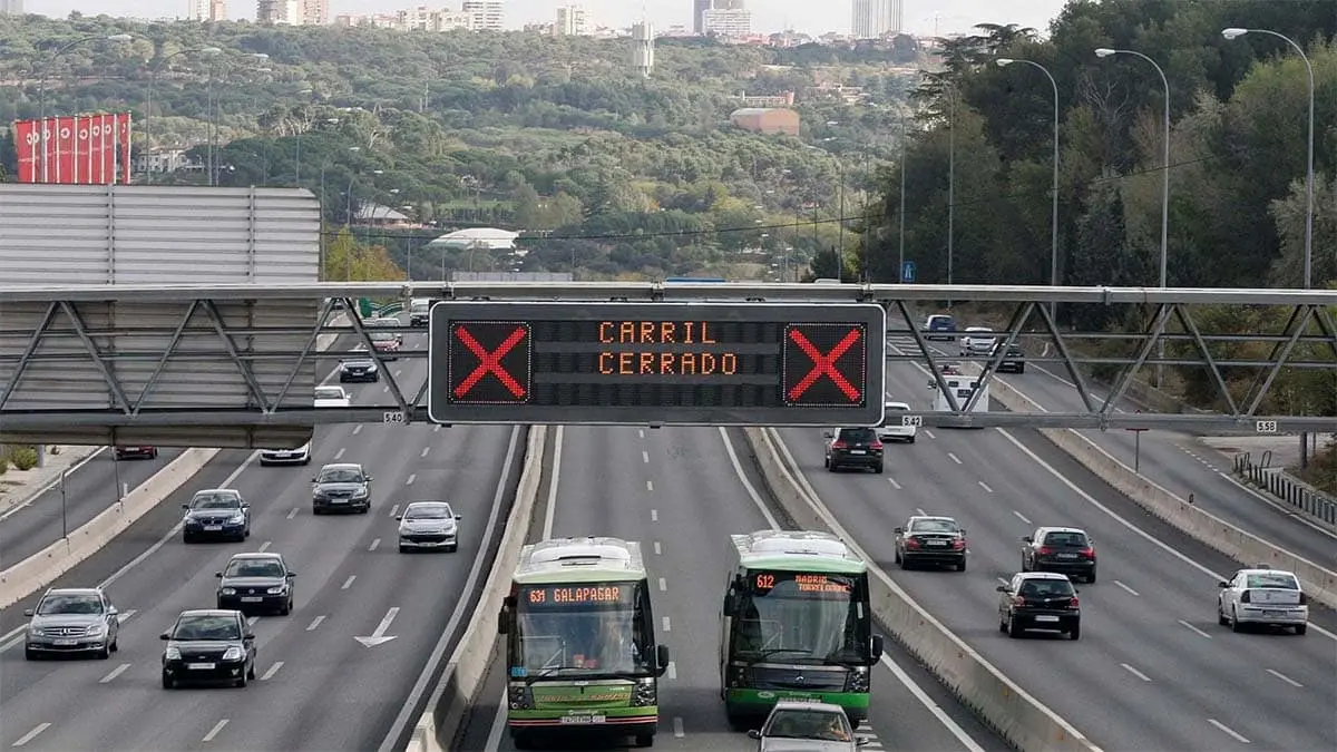 Autopista con tr&aacute;fico y se&ntilde;alizaci&oacute;n digital cerrando un carril.
