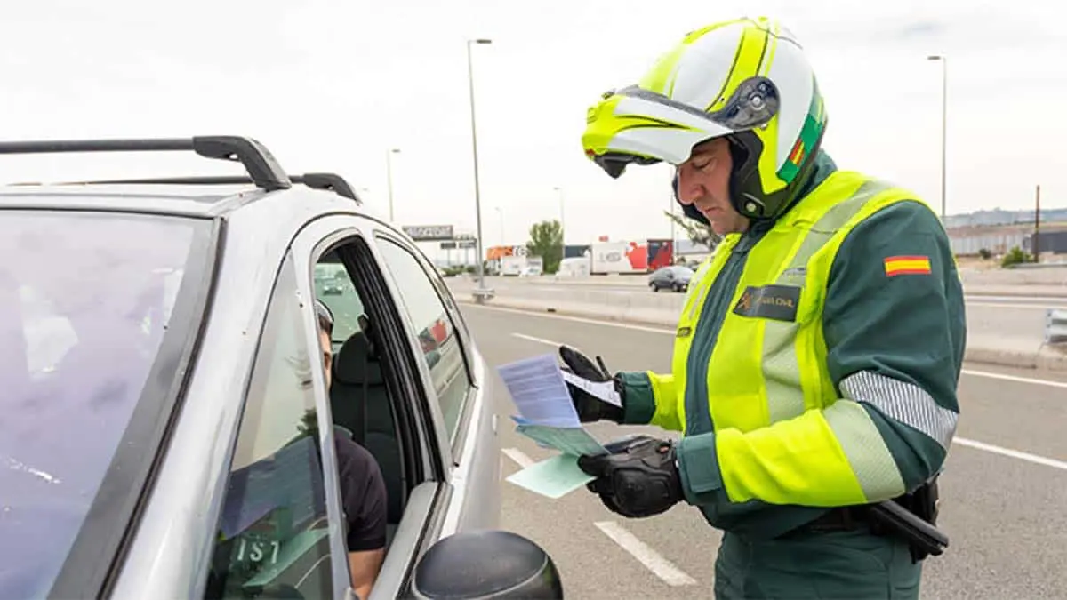 Agente de la guardia civil poniendo una multa por no llevar la baliza V16