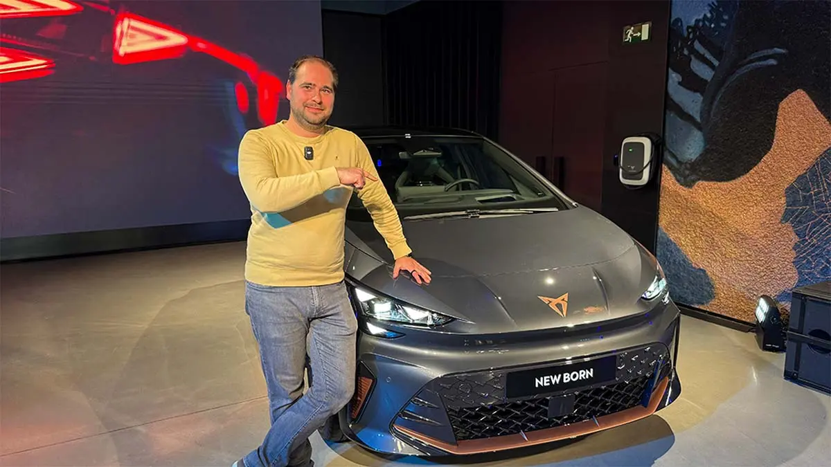 La imagen muestra a un hombre en un evento de movilidad el&eacute;ctrica, posando junto al nuevo CUPRA BORN, un coche el&eacute;ctrico de alto rendimiento y dise&ntilde;o vanguardista.