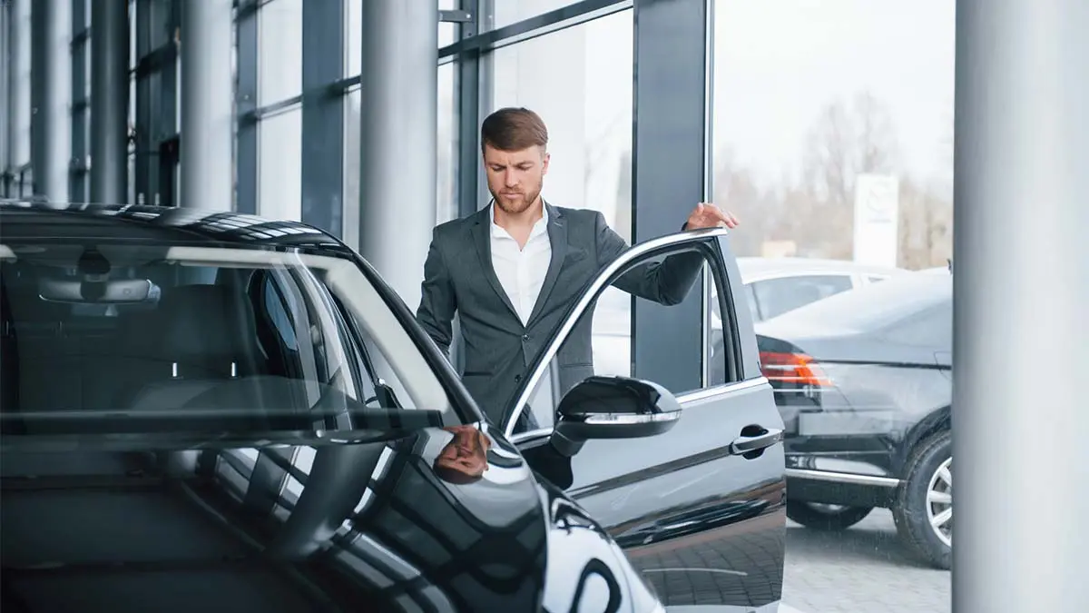 Profesional en un concesionario de coches el&eacute;ctricos, destacando la tendencia de renting para aut&oacute;nomos y la movilidad sostenible.