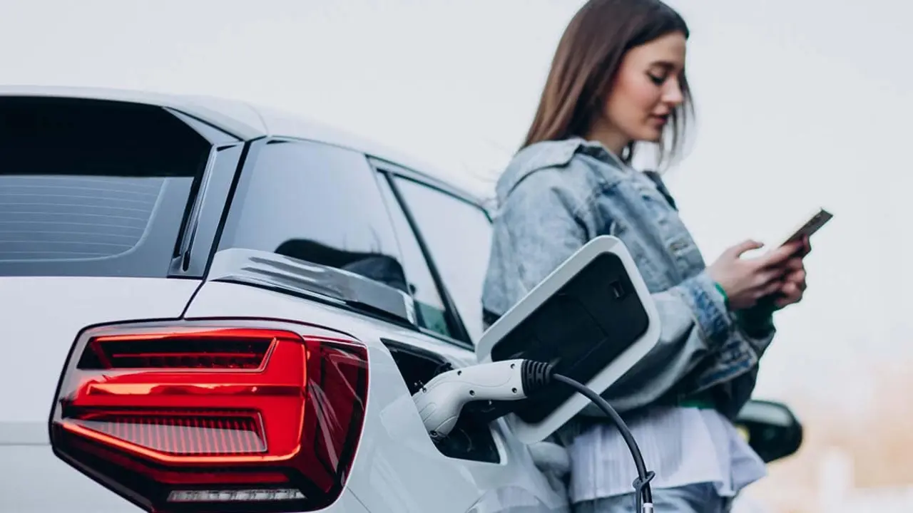 Mujer cargando coche el&eacute;ctrico