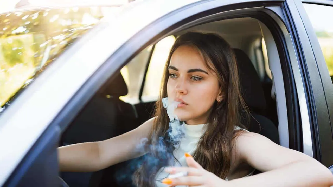 Chica fumando en el coche