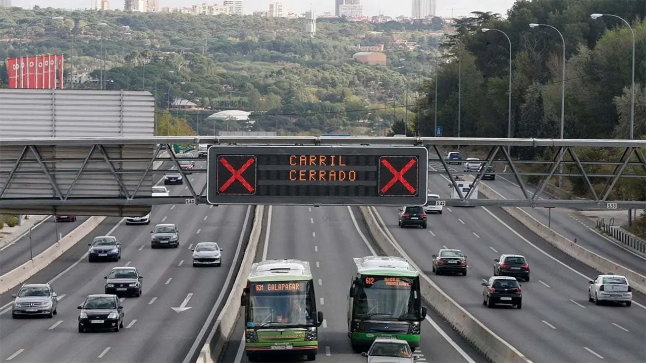 Autopista con tr&aacute;fico y se&ntilde;alizaci&oacute;n digital cerrando un carril.