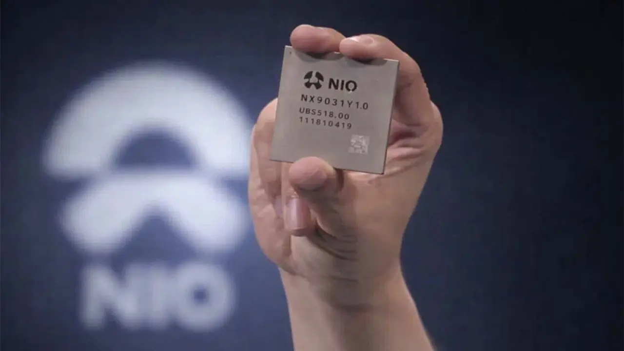 La imagen muestra una mano que sostiene un chip de NIO, destacando su apuesta por la innovaci&oacute;n en tecnolog&iacute;a de coches el&eacute;ctricos.