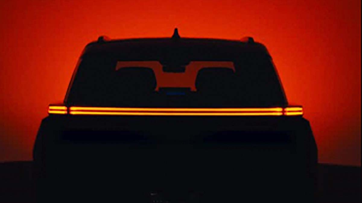 Imagen de un vehículo eléctrico en un fondo oscuro, resaltando sus luces LED rojas en la parte trasera.