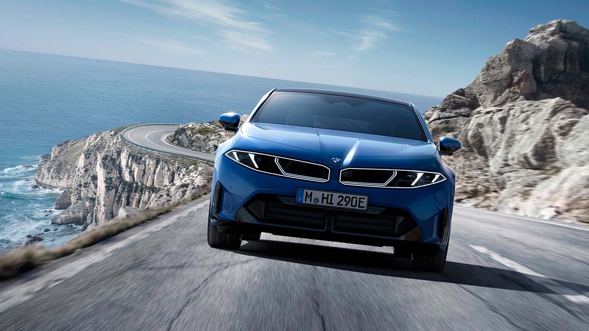 Nuevo BMW i3 2026 en ruta junto al mar con paisaje de acantilados.